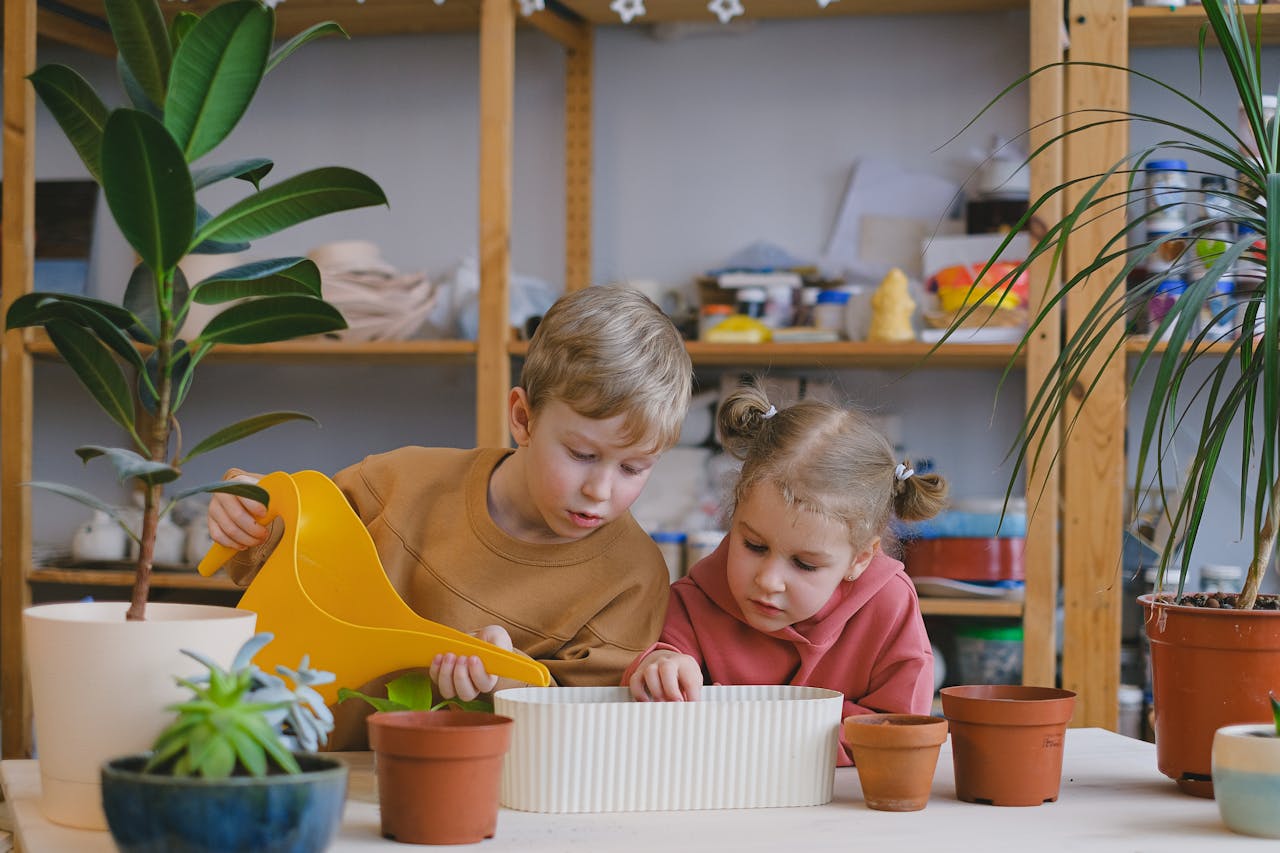 two children planting and watering plant - Plant Studio